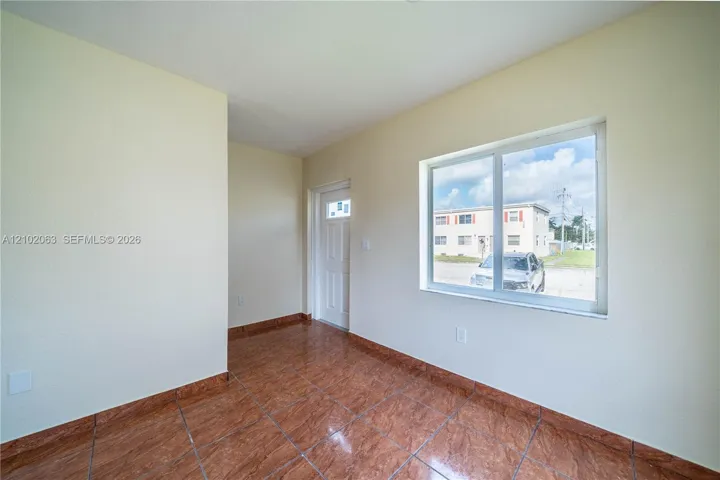 Neutral-toned walls complement the brown tile flooring throughout