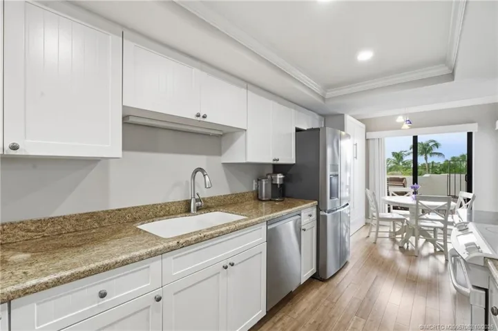 Generous counter and cabinet space complement the kitchen, which opens to the adjacent dining area and outdoor courtyard.