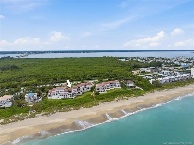 Aerial view identifying the residence while showcasing the community's exceptional barrier-island setting.