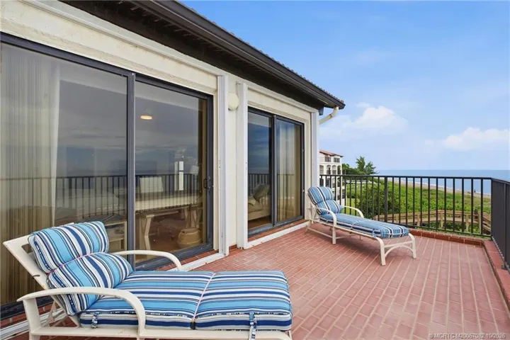 Expansive brick terrace off the primary suite with wide, unobstructed views of the beach and Atlantic Ocean.