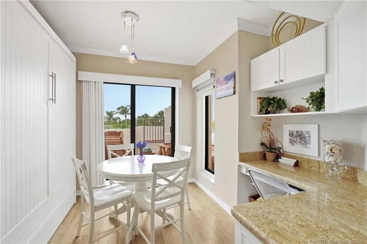 Casual dining area off the kitchen overlooks the private courtyard and includes a built-in desk/workspace and murphy bed.