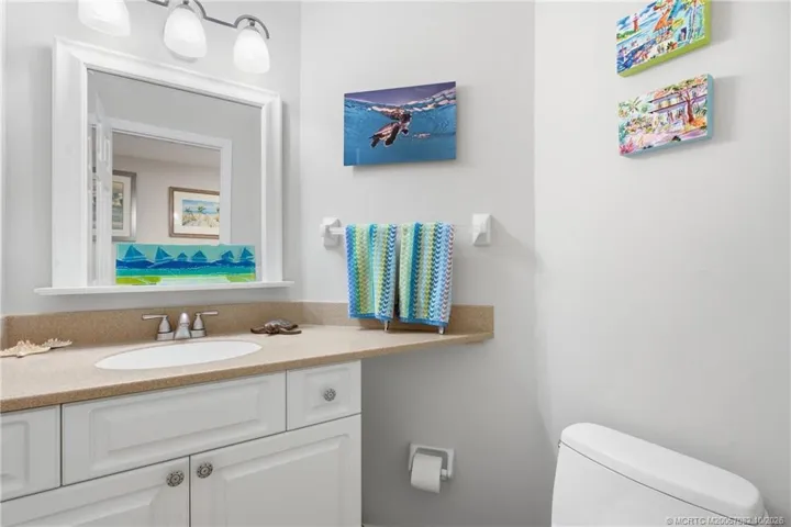 Convenient downstairs half bath with a spacious vanity and coastal-inspired décor.