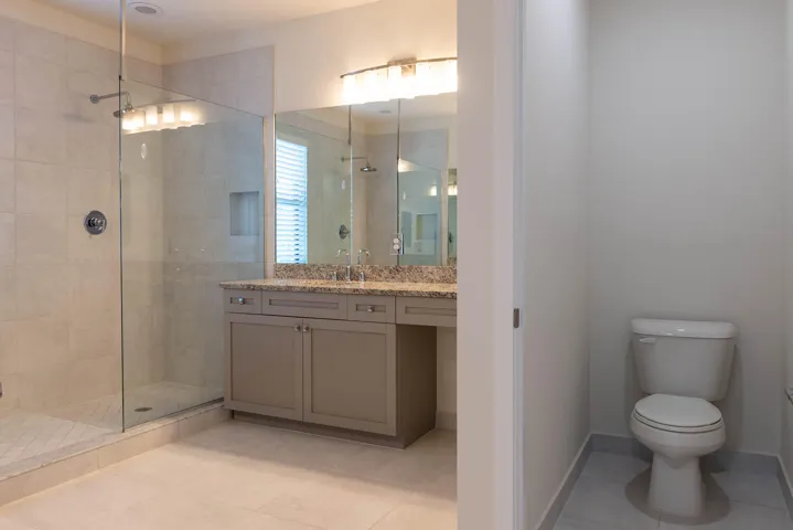 Walk-in shower with clear glass enclosure and tiled walls