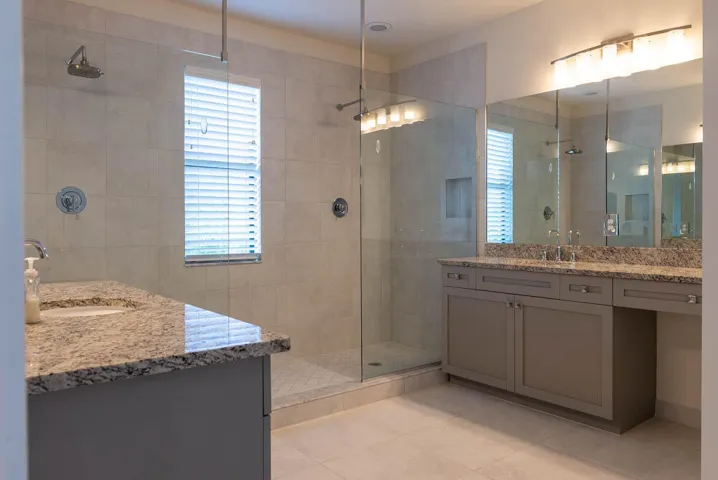 Dual vanity with granite countertops, undermount sinks, and integrated cabinetry