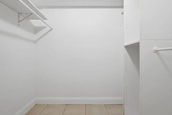One of the two walk in closets with closet cabinetry