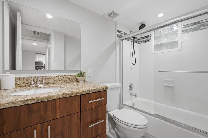 Master bathroom with combo tub shower-glass door and marble updated high vanity