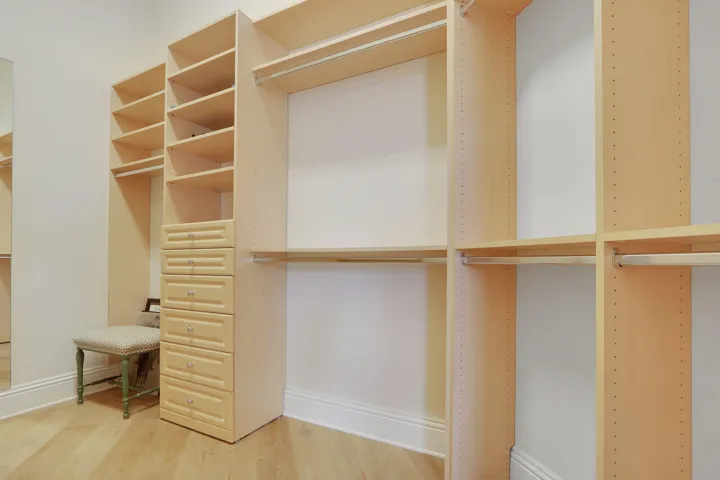 Custom closet system featuring extensive shelving, built-in drawers, and multiple hanging rods