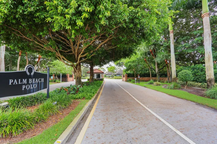 Gated entry with a prominent community sign and lush landscaping