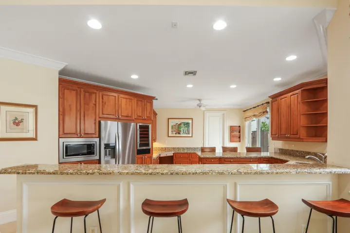 Kitchen featuring wood cabinetry, stainless steel appliances, and stone countertops