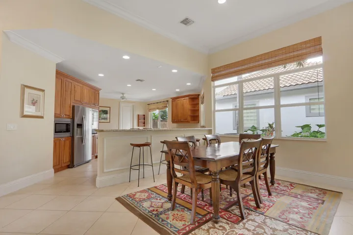 Tile flooring throughout, crown molding, a built-in breakfast bar, recessed lighting, and a large multi-pane window
