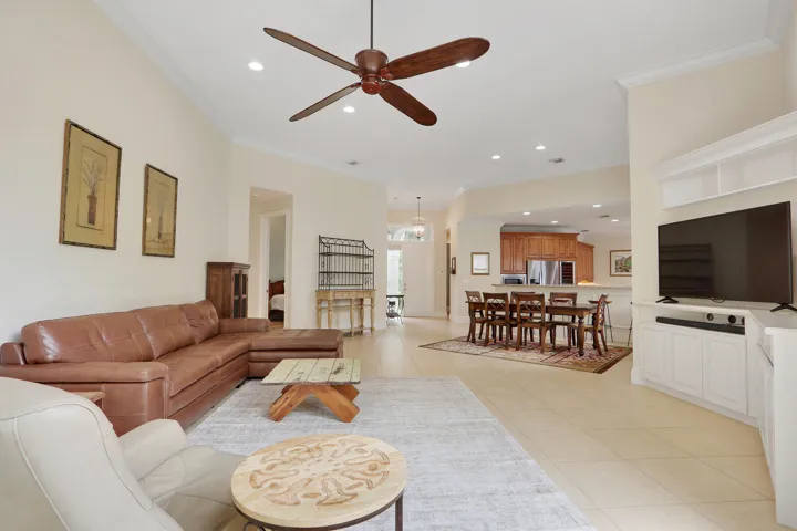 Vaulted ceilings with crown molding, ceiling fan, recessed lighting, tile flooring, and built-in white cabinetry with shelving