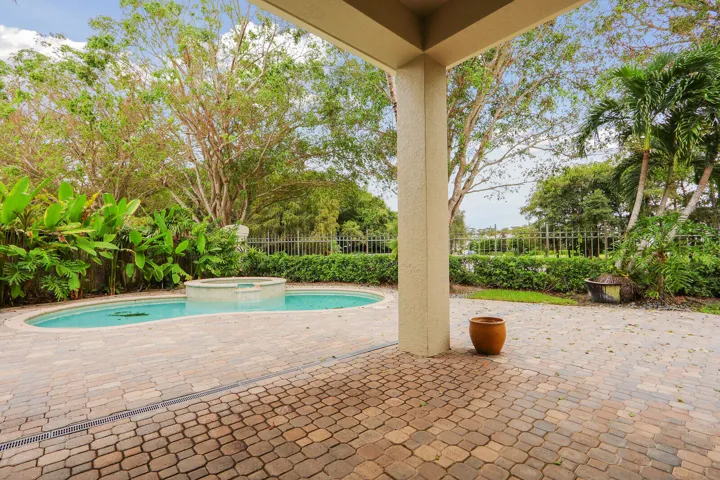 Expansive patio with pavers, a built-in pool, and integrated spa