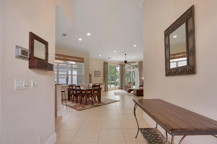 Vaulted ceiling, recessed lighting, tile flooring, and a ceiling fan