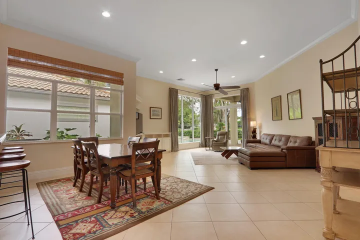 Expansive room featuring light-toned tile flooring, recessed lighting, and crown molding