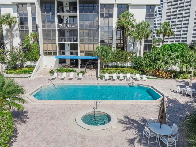 Well maintained pool deck with hot tub and plenty of chairs