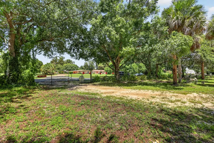 Expansive natural lot featuring mature trees and a gated entrance