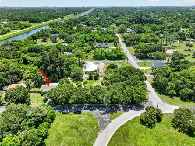 Aerial perspective featuring a residential property surrounded by mature trees