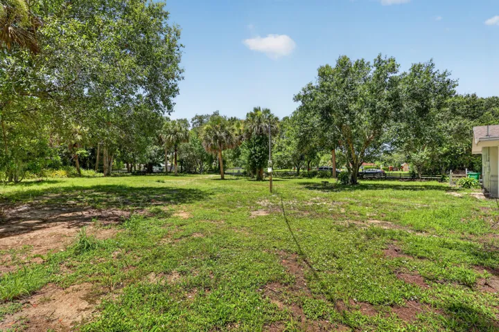 Expansive grassed area featuring mature trees and a sunny disposition