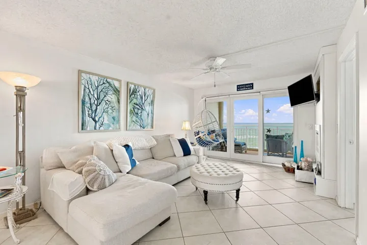 Living area featuring a ceiling fan, tiled flooring, and sliding glass doors to the exterior