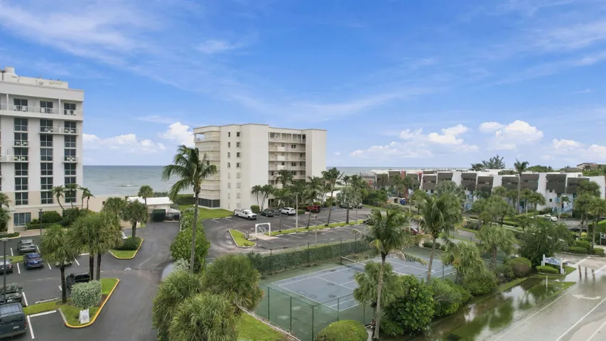 Oceanfront property featuring multiple high-rise buildings, tennis courts, and ample parking