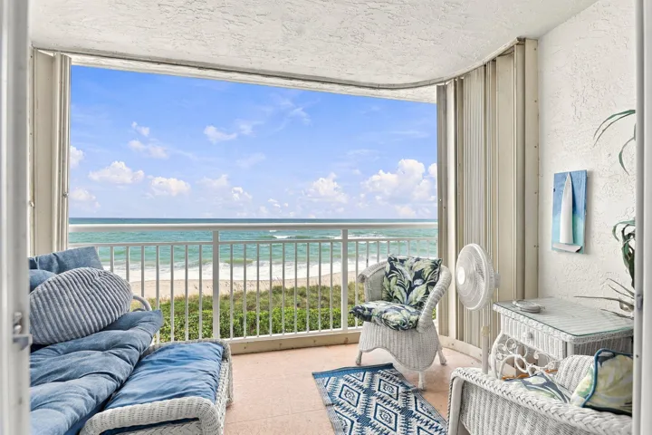 Balcony with a metal railing, concrete flooring, and accordion hurricane shutters