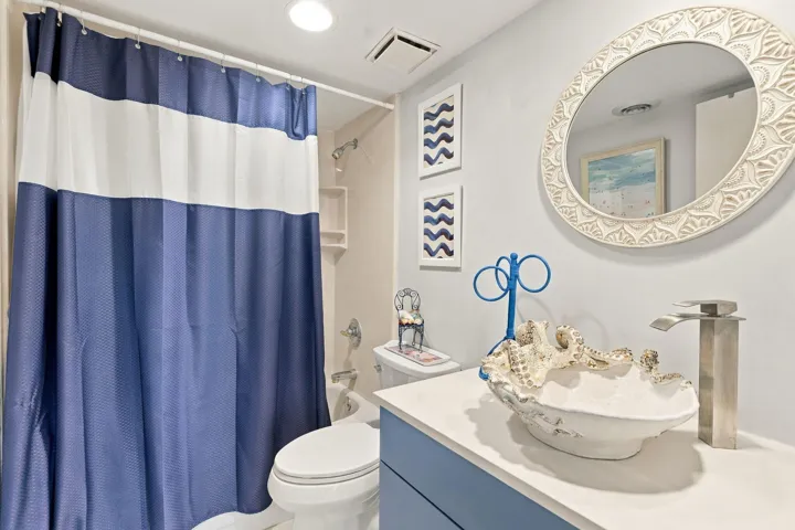 White vanity with a vessel sink and contemporary faucet