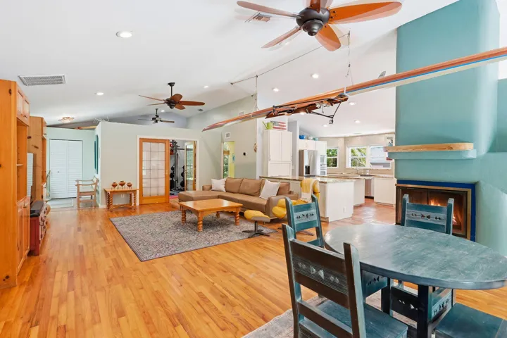 Vaulted ceiling, recessed lighting, oak wood flooring, and a 3 sided wood burning fireplace