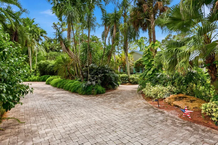 Circular driveway with lush landscaping makes the house feel like a secret garden
