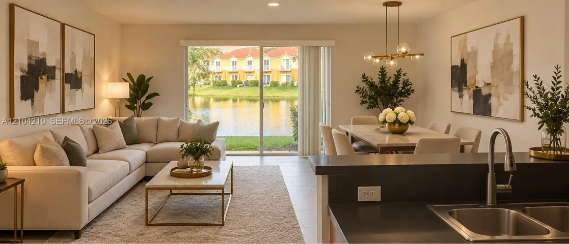 Open-concept living space with a sliding glass door, a dining area, and a kitchen island with a double basin sink