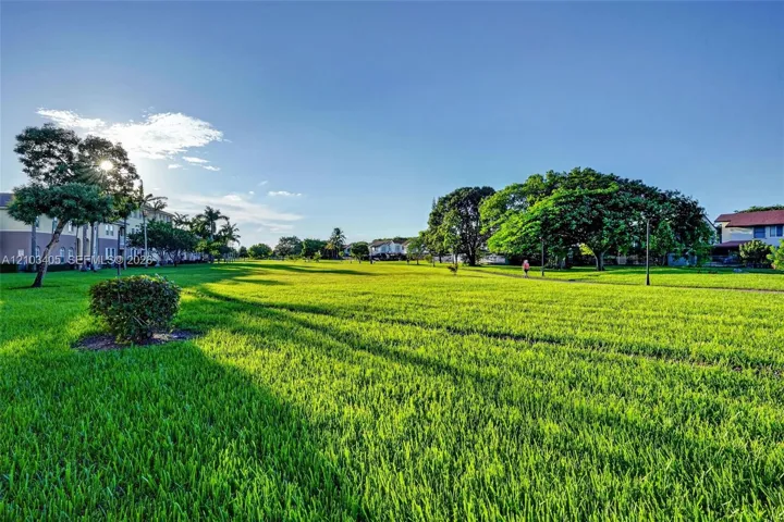 Expansive green space featuring mature trees and established landscaping