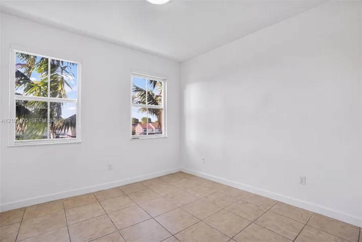 Neutral-toned ceramic tile flooring, clean white wall finishes, and dual single-hung windows with white frames