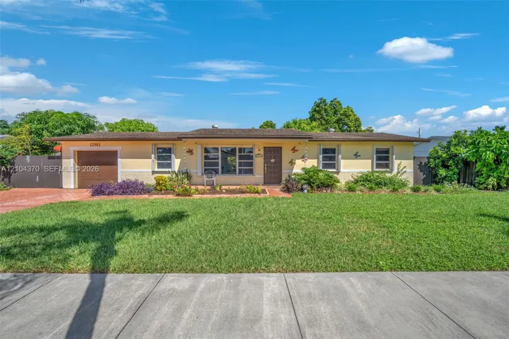 Single-story ranch-style residence featuring a stucco exterior, integrated one-car garage, multi-pane windows, and a paved driveway