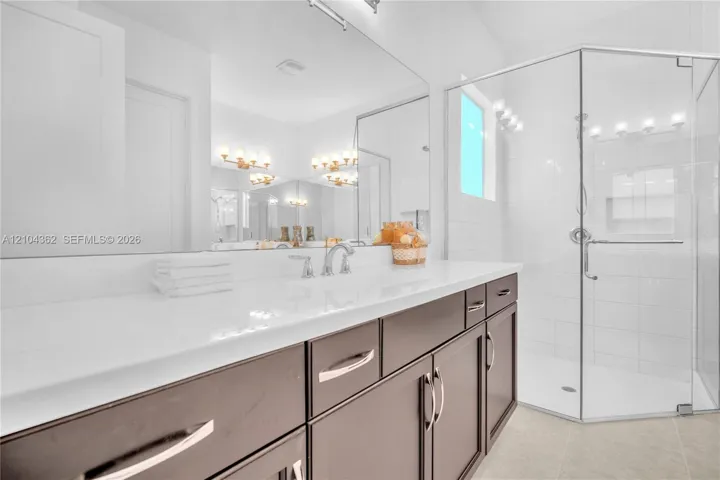 Primary Bath. Extended tile to ceiling in walk in shower. Frameless custom shower enclosure.