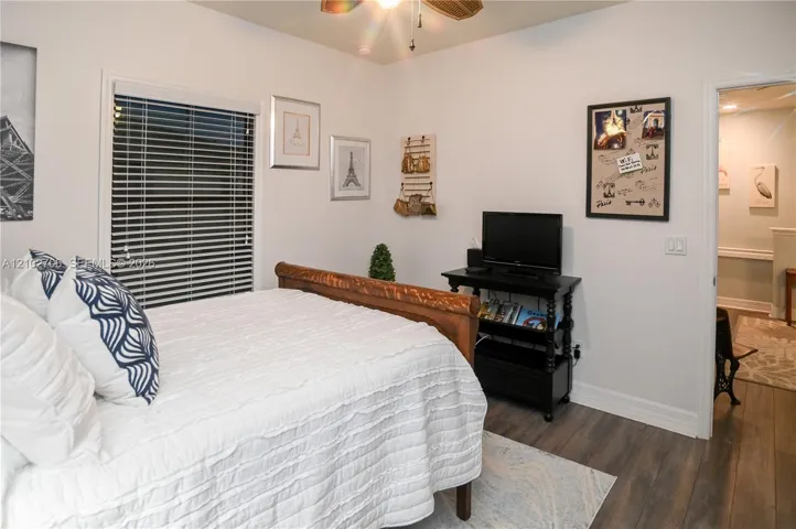 Wood-finish flooring, horizontal window blinds, and a ceiling fan with integrated lighting