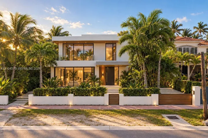 Contemporary architecture with expansive glass panels, a flat roof, a private balcony, a modern entry door, and a manicured tropical landscape