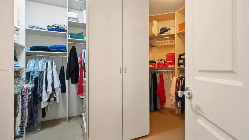 Walk-in closet featuring floor-to-ceiling built-in shelving, integrated garment hanging rods, and central double-door cabinetry
