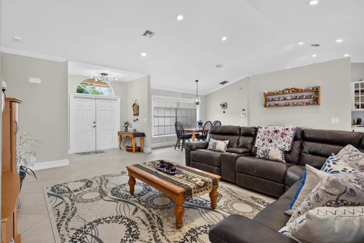 Tile flooring extends throughout the living area, featuring recessed lighting and a vaulted ceiling
