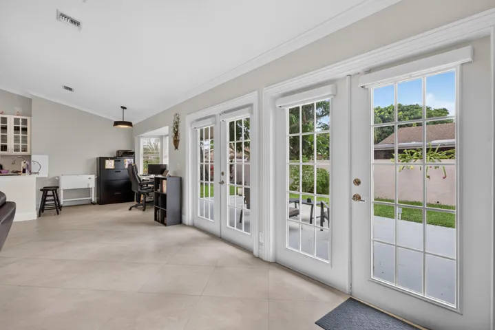Vaulted ceiling, recessed lighting, tile flooring, built-in cabinetry, and French doors