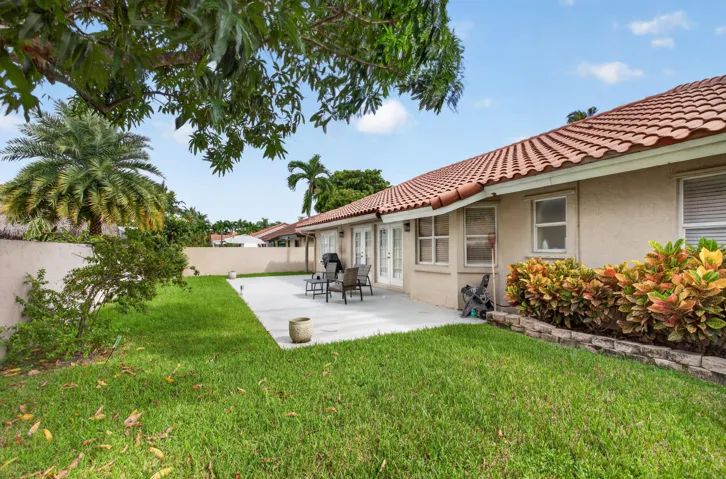 beautiful backyard featuring a manicured lawn, concrete patio, and lush landscaping