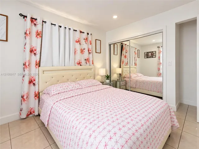 Recessed lighting, mirrored closet doors, tile flooring, and a built-in closet niche