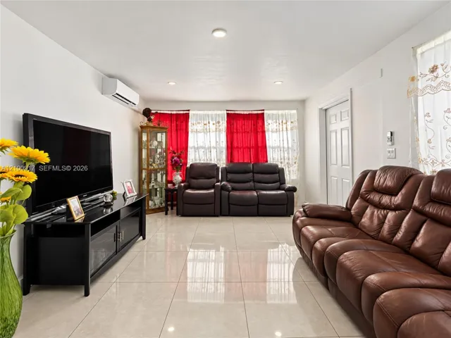 Recessed ceiling lighting, durable tile flooring, split-system air conditioning unit, and a paneled interior door