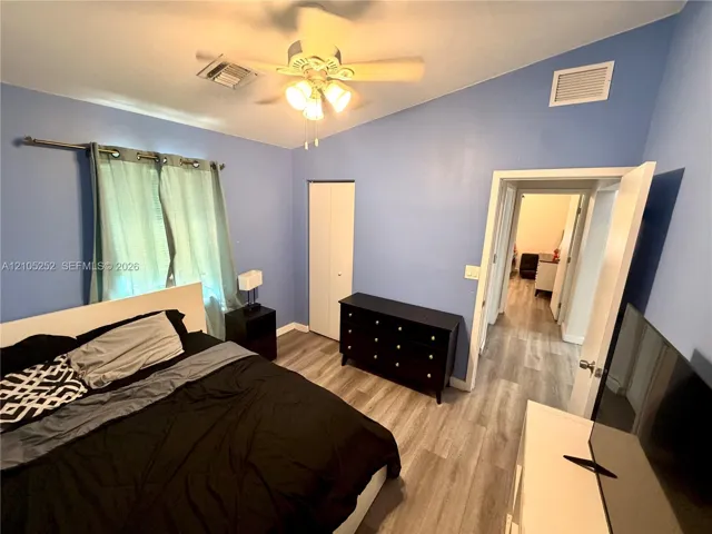 Vaulted ceilings with a ceiling fan, wood-finish flooring, and bi-fold closet doors