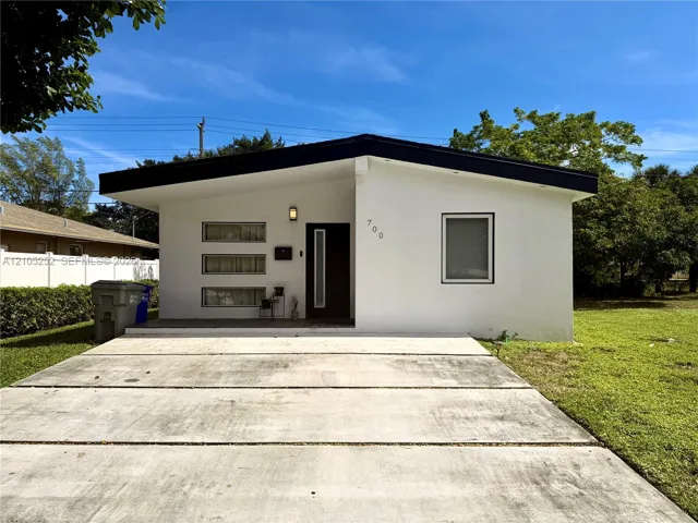 Contemporary architectural style with a flat black roofline, white stucco exterior, and a dark entry door