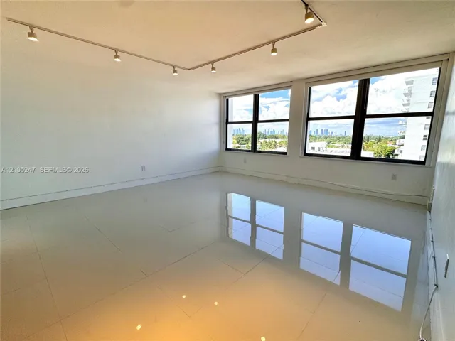 Track lighting fixtures, expansive windows, city horizon, and reflective tile flooring
