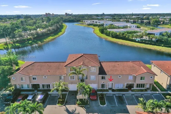 Multi-story stucco exterior featuring a tile roof and waterfront positioning