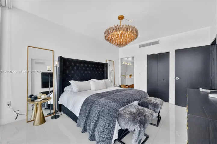 White tile flooring, modern chandelier, dark-toned doors, built-in air conditioning vent