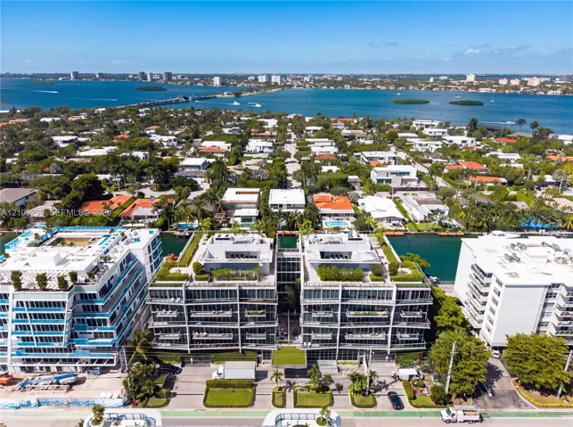 Multi-story residential buildings featuring balconies, green rooftops, and surrounding waterways