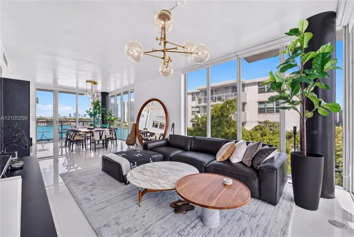 Expansive window walls, glossy tile flooring, recessed lighting, and a modern chandelier
