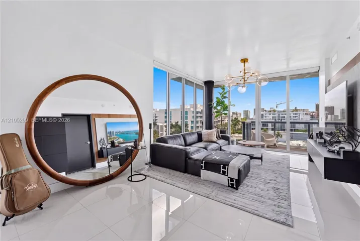 Expansive window wall with balcony access, recessed lighting, and a contemporary chandelier