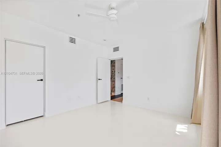 Recessed lighting, smooth white walls, and a ceiling fan